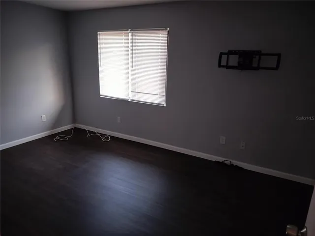 a view of a room with wooden floor and a window