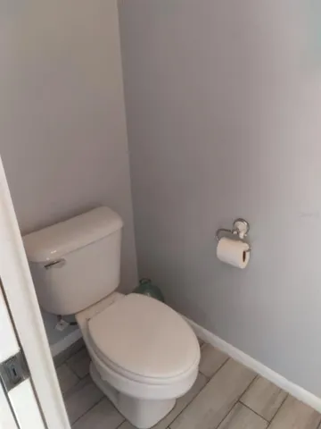 a white toilet sitting next to a shower