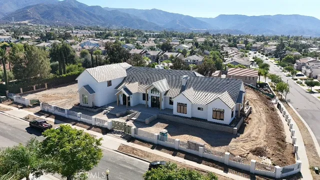 an aerial view of a house with a mountain