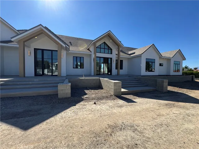 a front view of a house with a yard outdoor seating and garage
