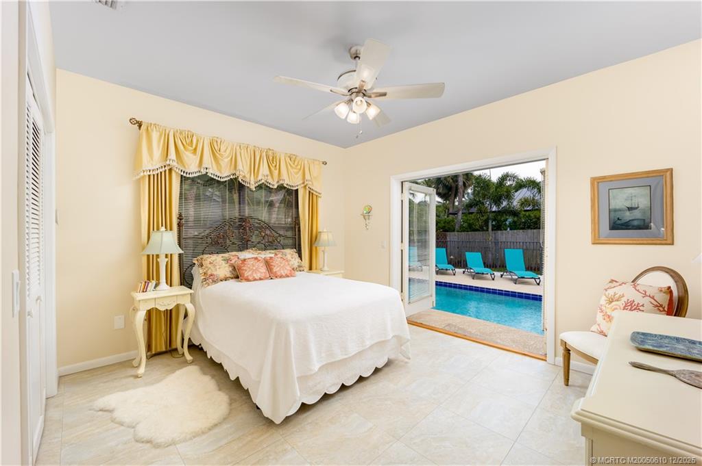 8 Kingston Court Stuart, FL 34996 - Photo 24 of 51 a bedroom with a bed and a chandelier
