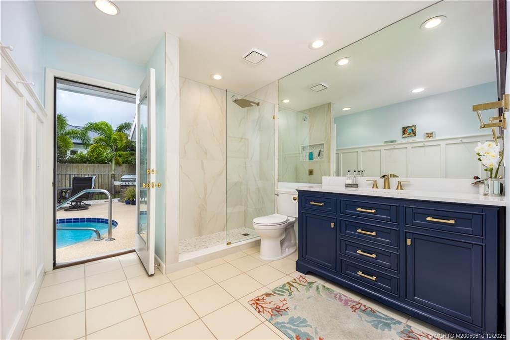 8 Kingston Court Stuart, FL 34996 - Photo 25 of 51 a spacious bathroom with a granite countertop sink a toilet a mirror and shower