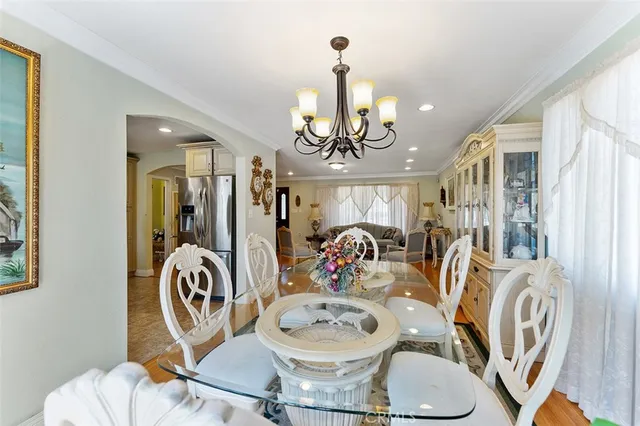 a view of a dining room with furniture a chandelier and wooden floor
