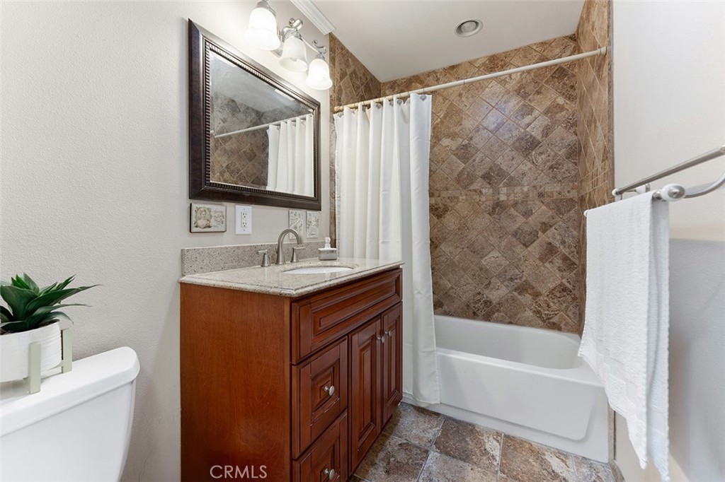 5441 North Calera Avenue Covina, CA 91722 - Photo 21 of 32 a bathroom with a granite countertop sink a mirror a shower and a bathtub