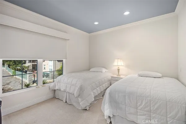 a bedroom with two beds and a large window