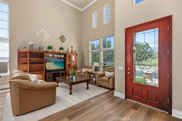 a living room with furniture a flat screen tv and a floor to ceiling window