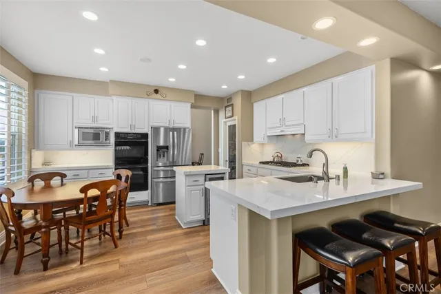 a kitchen with refrigerator a stove and chairs