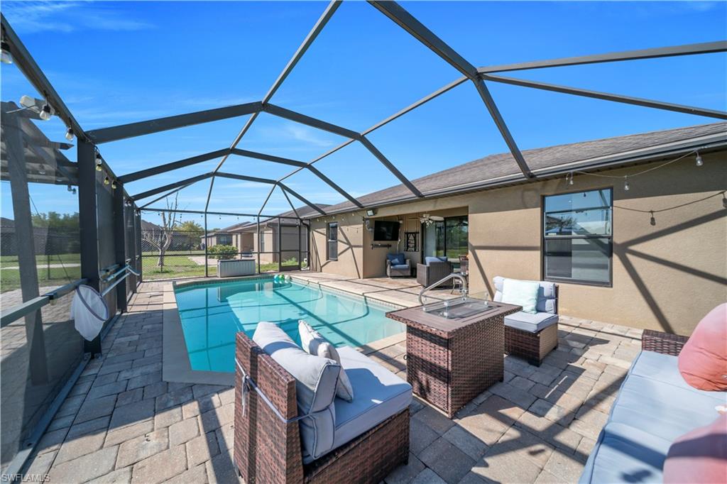 175 Shadowview Court Lehigh Acres, FL 33974 - Photo 10 of 39 a view of a patio with couches table and chairs under an umbrella
