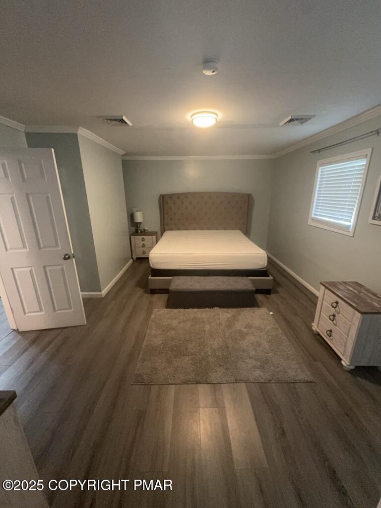 5228 Hummingbird Drive Pocono Summit, PA 18346 - Photo 11 of 28 a bedroom with a bed and wooden floor