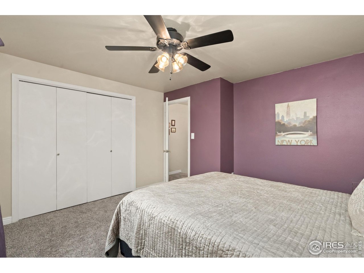 707 3rd Street, Unit 5 Windsor, CO 80550 - Photo 16 of 18 a bedroom with a large bed and a chandelier