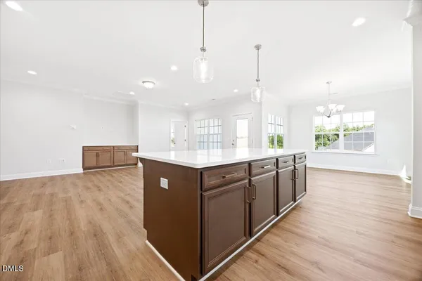 a large kitchen with kitchen island wooden floors and white cabinets