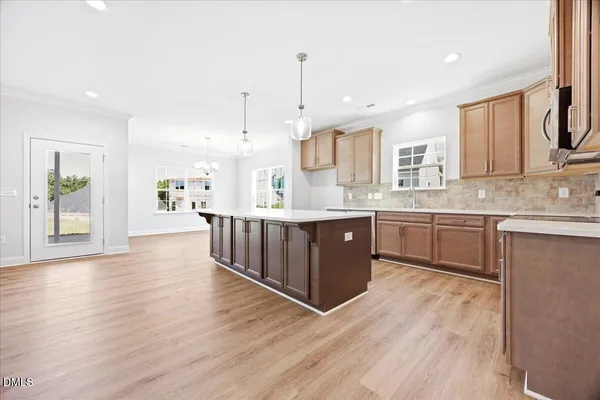 a kitchen with stainless steel appliances kitchen island wooden cabinets a center island and a window