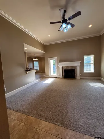 a view of a livingroom with a fireplace a chandelier and windows