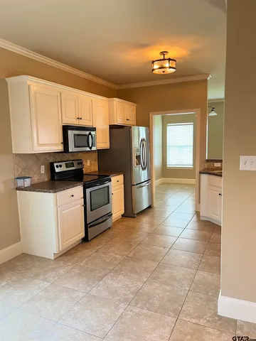 a kitchen with stainless steel appliances a stove a refrigerator a sink a microwave and cabinets