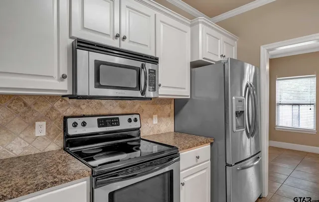 a kitchen with refrigerator a stove and cabinets