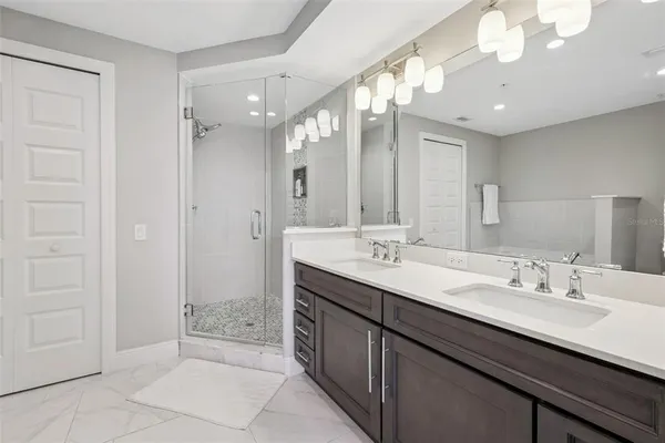 a bathroom with a double vanity sink a mirror and a shower