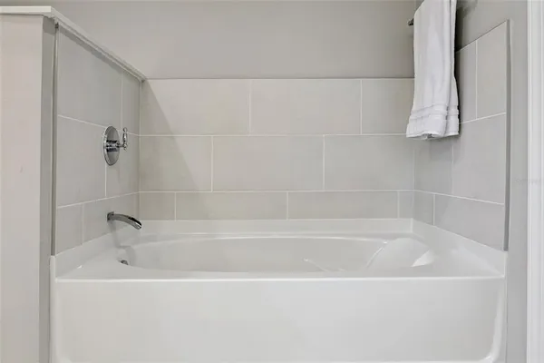 a white bath tub sitting next to a shower