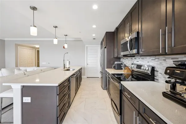 a kitchen with kitchen island granite countertop a sink a counter space appliances and cabinets
