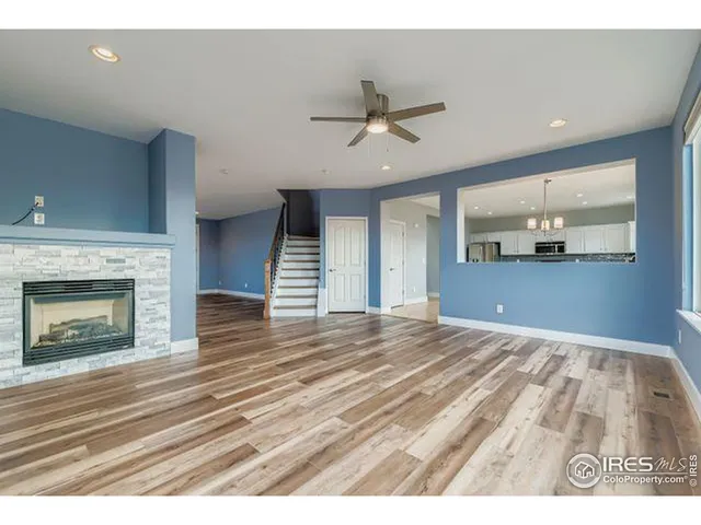a view of empty room with wooden floor and fireplace