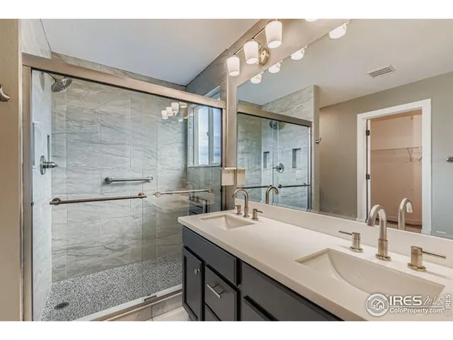 a bathroom with a sink mirror and a shower