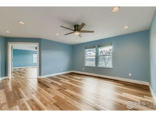 a view of empty room with window and wooden floor
