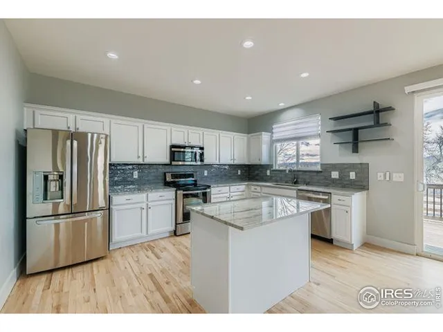 a kitchen with stainless steel appliances granite countertop a refrigerator sink and stove