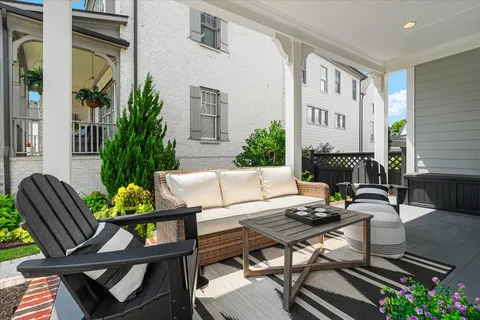 a view of a hallway to a livingroom with furniture wooden floor and a chandelier