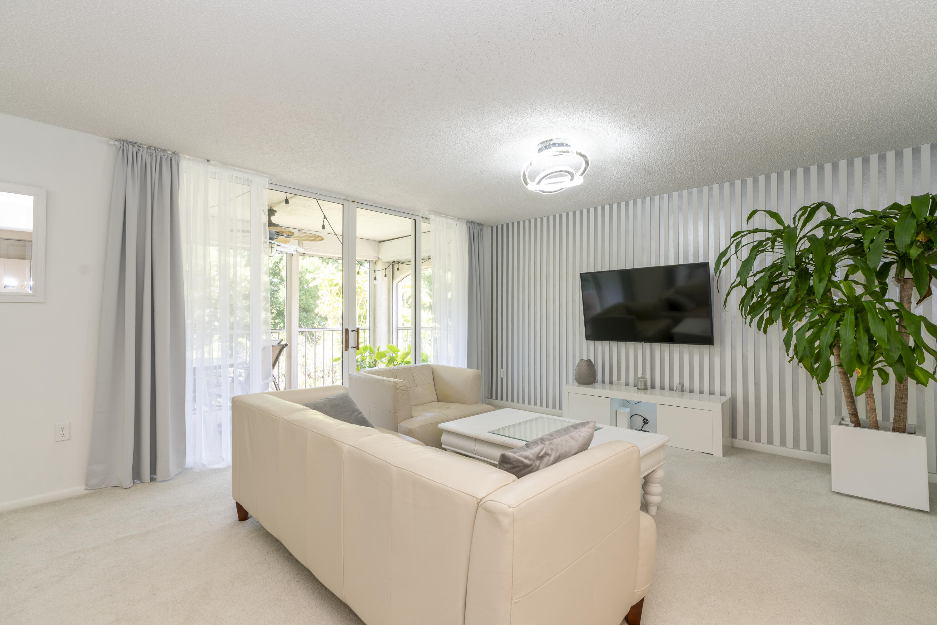 106 Half Moon Circle, Unit H2 Hypoluxo, FL 33462 - Photo 15 of 70 a living room with furniture and a flat screen tv