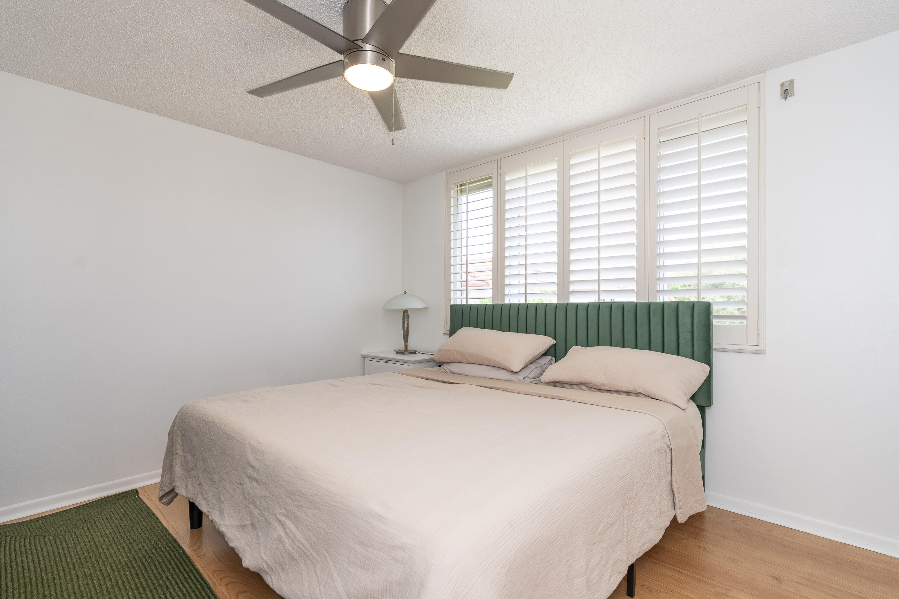 106 Half Moon Circle, Unit H2 Hypoluxo, FL 33462 - Photo 33 of 70 a bedroom with a bed and a ceiling fan