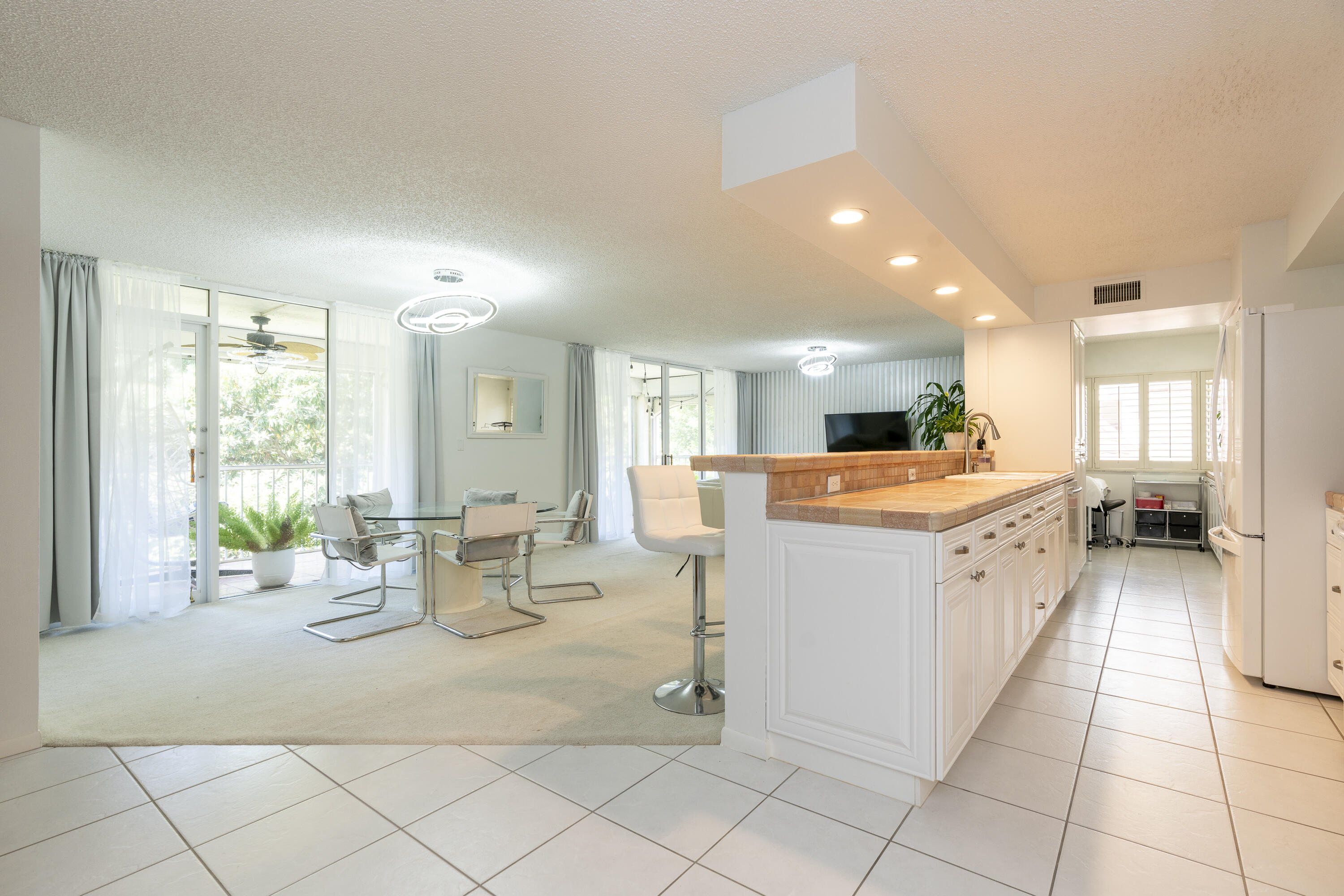 106 Half Moon Circle, Unit H2 Hypoluxo, FL 33462 - Photo 4 of 70 a kitchen with a sink and chairs