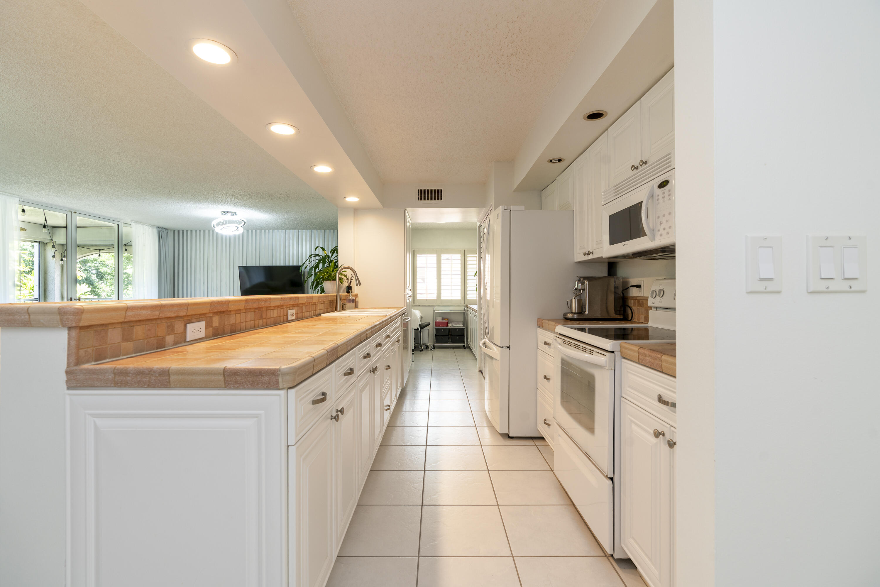 106 Half Moon Circle, Unit H2 Hypoluxo, FL 33462 - Photo 6 of 70 a large kitchen with stainless steel appliances kitchen island granite countertop a large counter top and a stove top oven