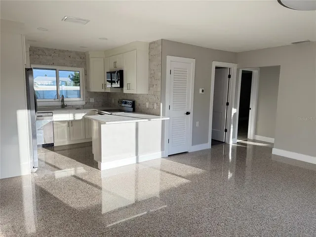 a kitchen with a stove a refrigerator and a stove top oven