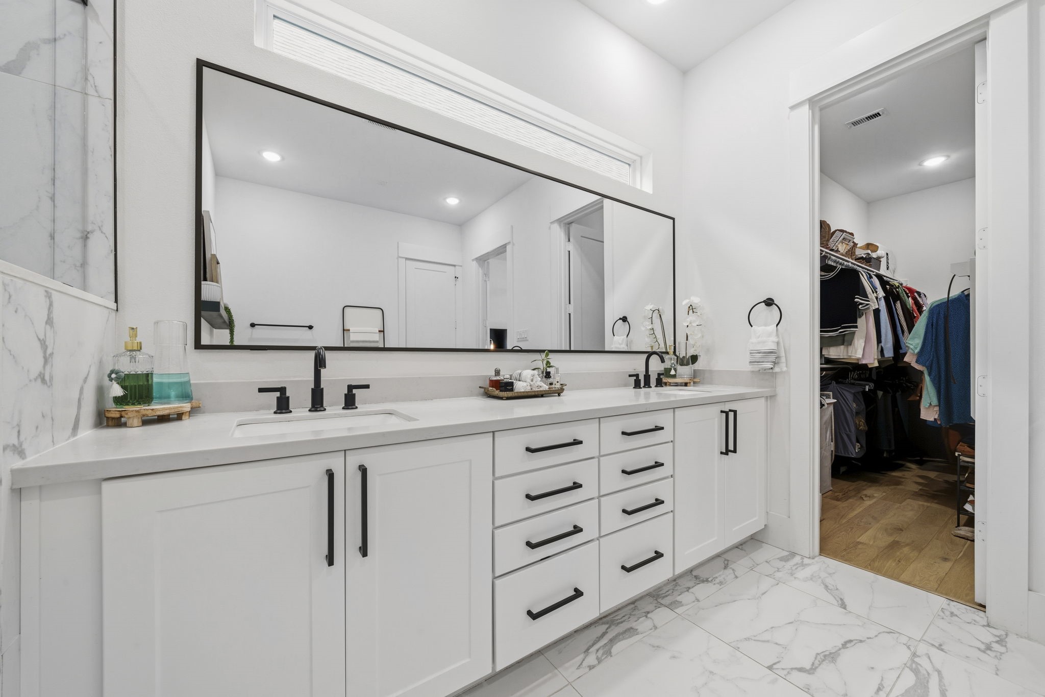 9018 Wellspring Drive Houston, TX 77080 - Photo 12 of 25 The primary bathroom’s dual-sink vanity features an expansive custom mirror and bright cabinetry, providing plenty of counter space and drawer storage for effortless morning routines.