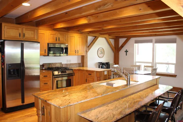 a kitchen with stainless steel appliances granite countertop a sink a stove and a refrigerator