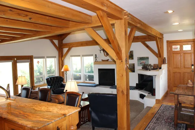 a large living room with furniture a fireplace and a floor to ceiling window
