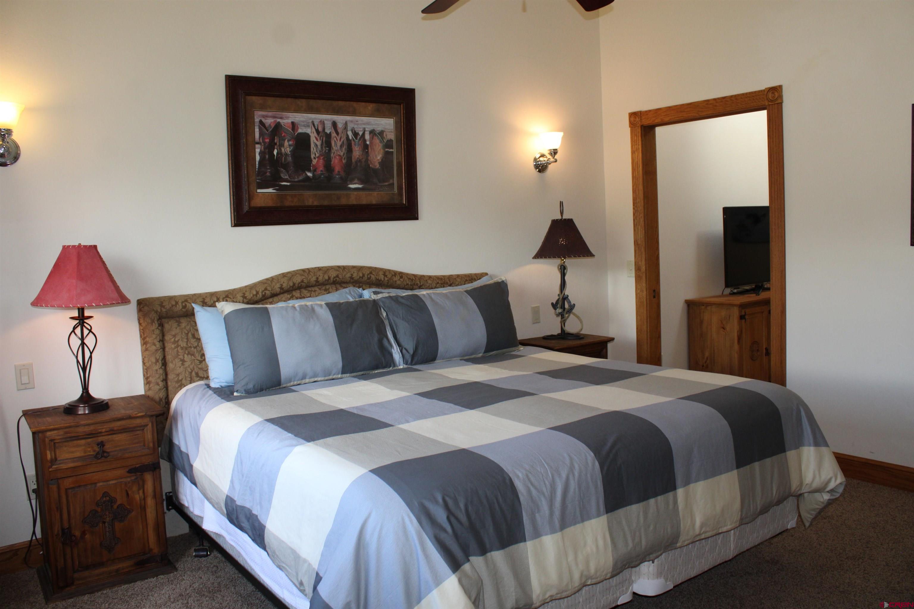 28 Holly Tree Circle Pagosa Springs, CO 81147 - Photo 19 of 27 a bedroom with a bed and a flat screen tv