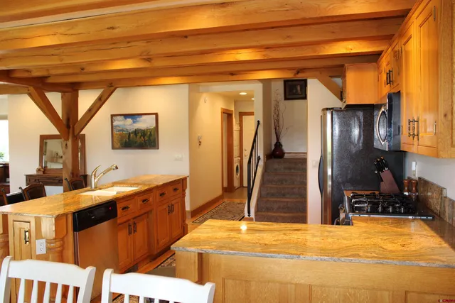 a room with stainless steel appliances kitchen island granite countertop a refrigerator and a stove