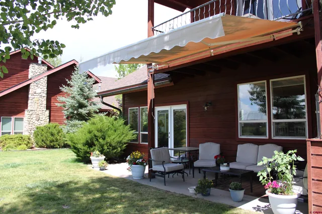a patio with table and chairs and potted plants
