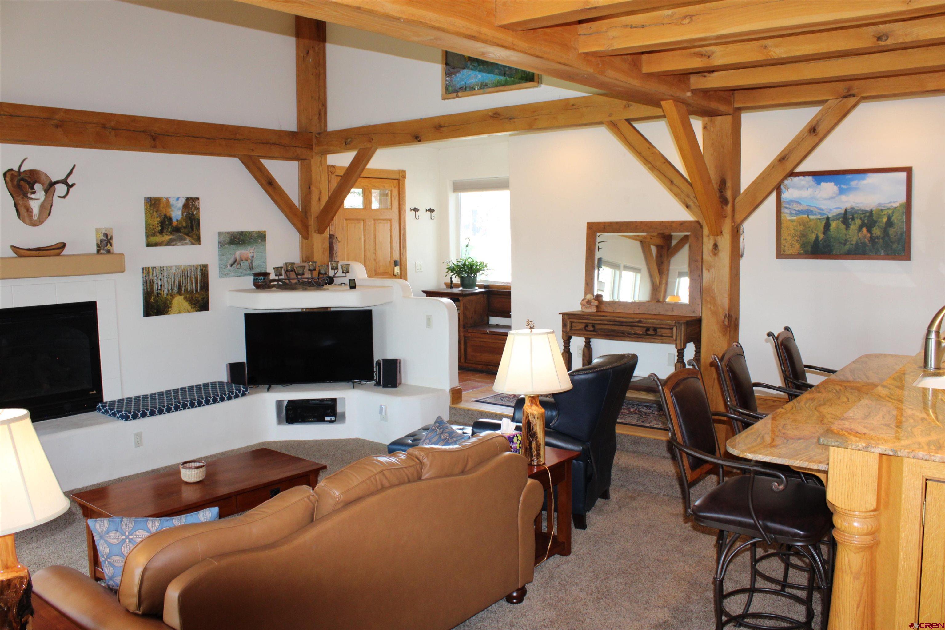 28 Holly Tree Circle Pagosa Springs, CO 81147 - Photo 9 of 27 a living room with furniture a flat screen tv and a floor to ceiling window