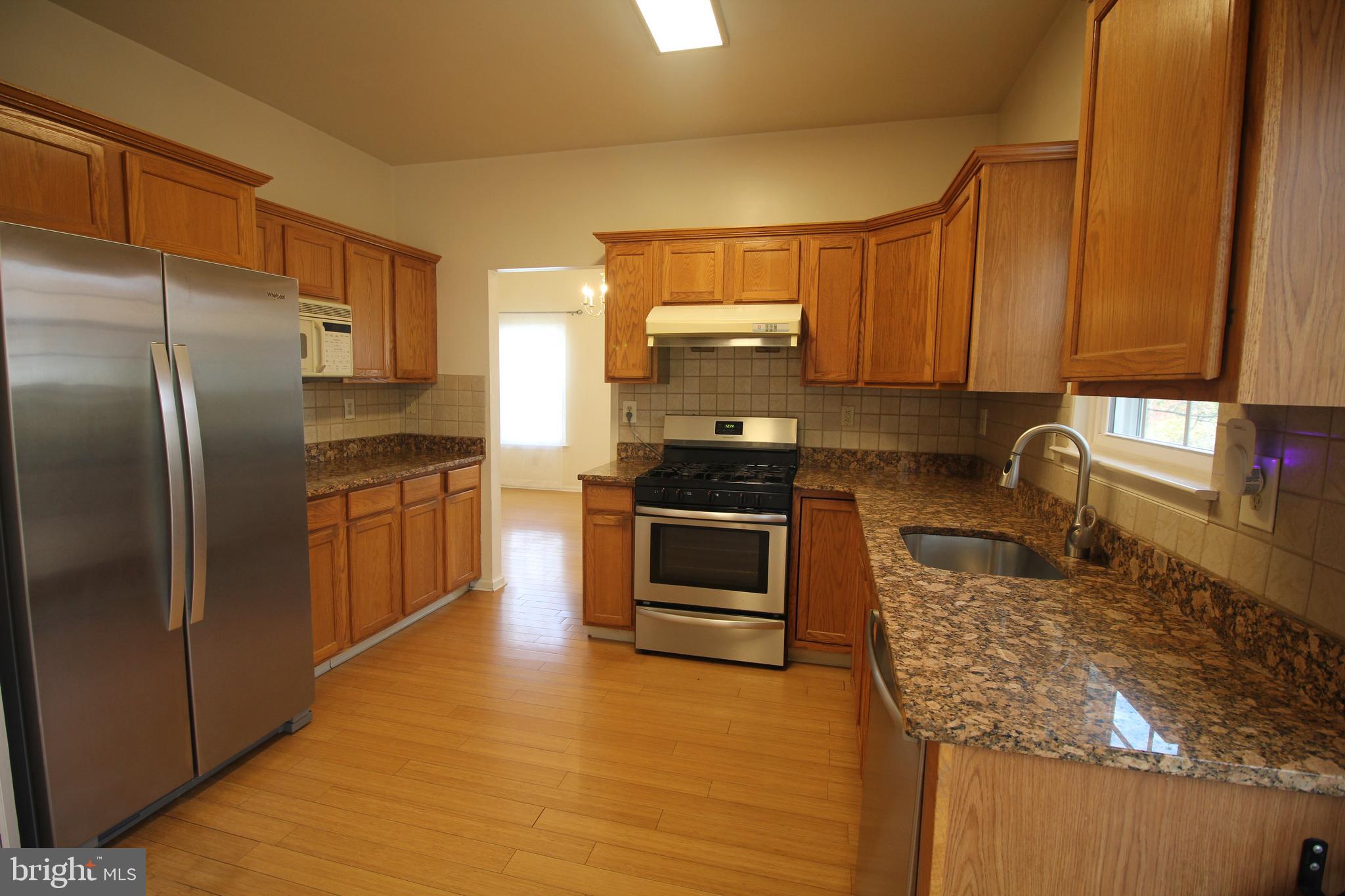 92 Harvard Circle Princeton, NJ 08540 - Photo 12 of 40 a kitchen with stainless steel appliances granite countertop a stove a sink and a refrigerator