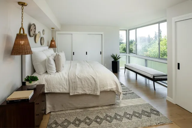 a bedroom with a bed a lamp and a window