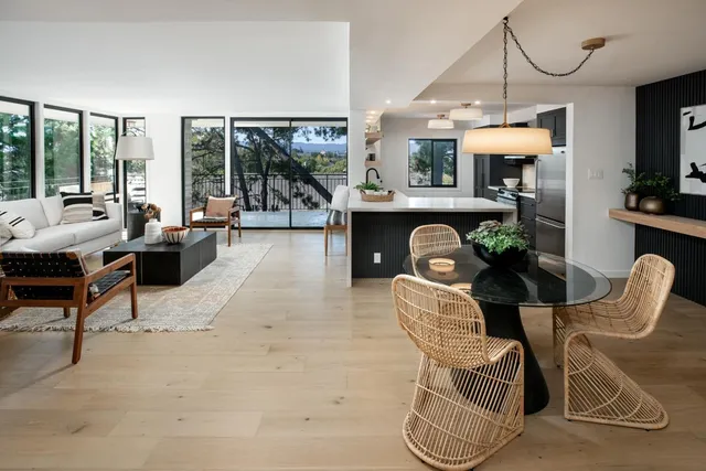 a living room with furniture a chandelier and a floor to ceiling window