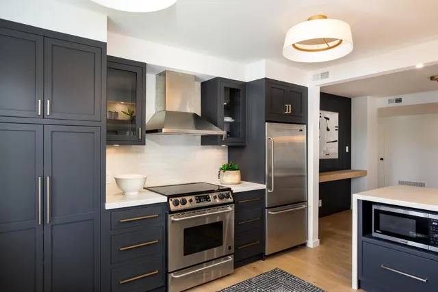 a kitchen with stainless steel appliances granite countertop a refrigerator and a stove