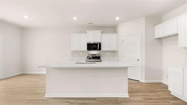 a kitchen with a sink and wooden floor