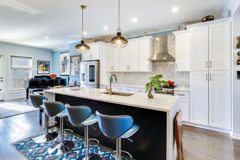 a kitchen with kitchen island granite countertop a sink and a refrigerator