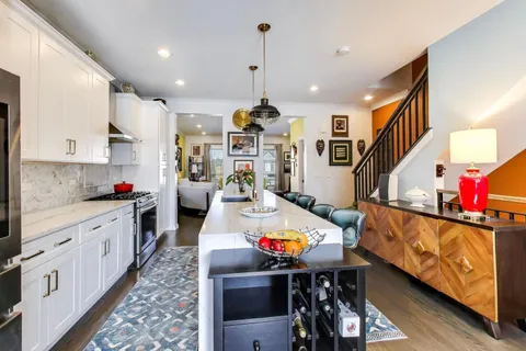 a large kitchen with stainless steel appliances kitchen island granite countertop a stove a sink dishwasher and cabinets with wooden floor