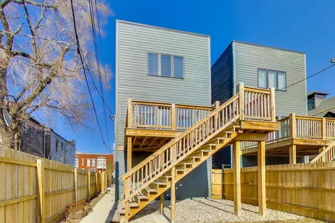 a view of a house with wooden stairs and stairs
