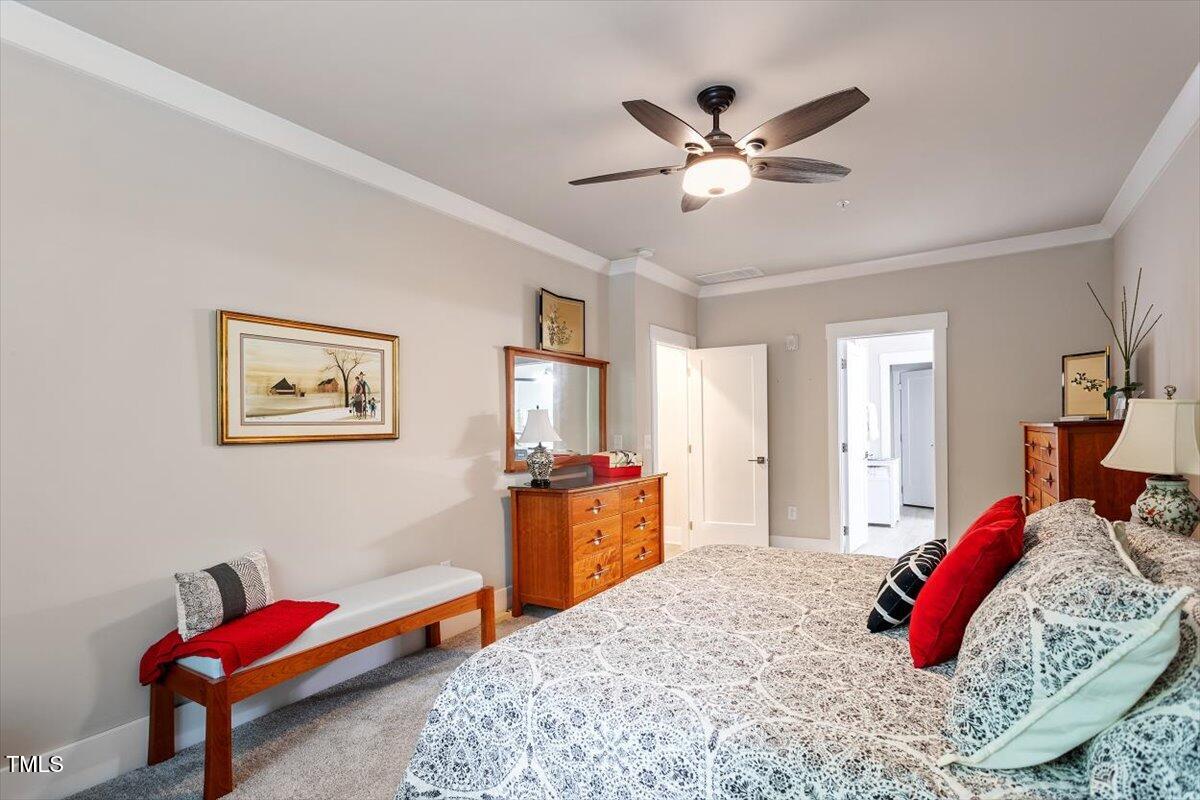 10310 Sablewood Drive, Unit 115 Raleigh, NC 27617 - Photo 16 of 28 a bedroom with a bed and a chandelier