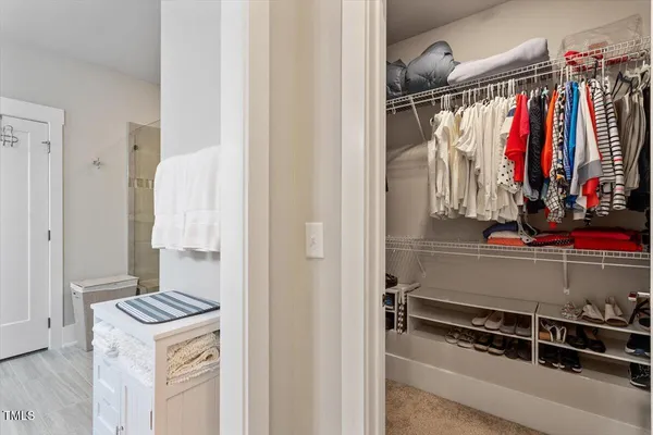 a view of walk in closet with clothes and shoes