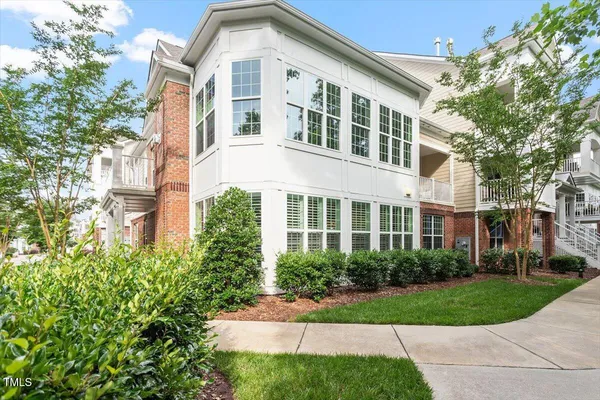 front view of a brick house with a yard